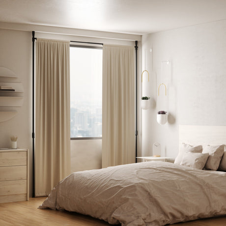 Bedroom with sheer curtains hung on a ceiling-mounted curtain rod beside a bed and window